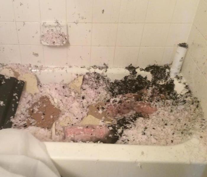 Insulation with soot in a bathtub after a fire damage